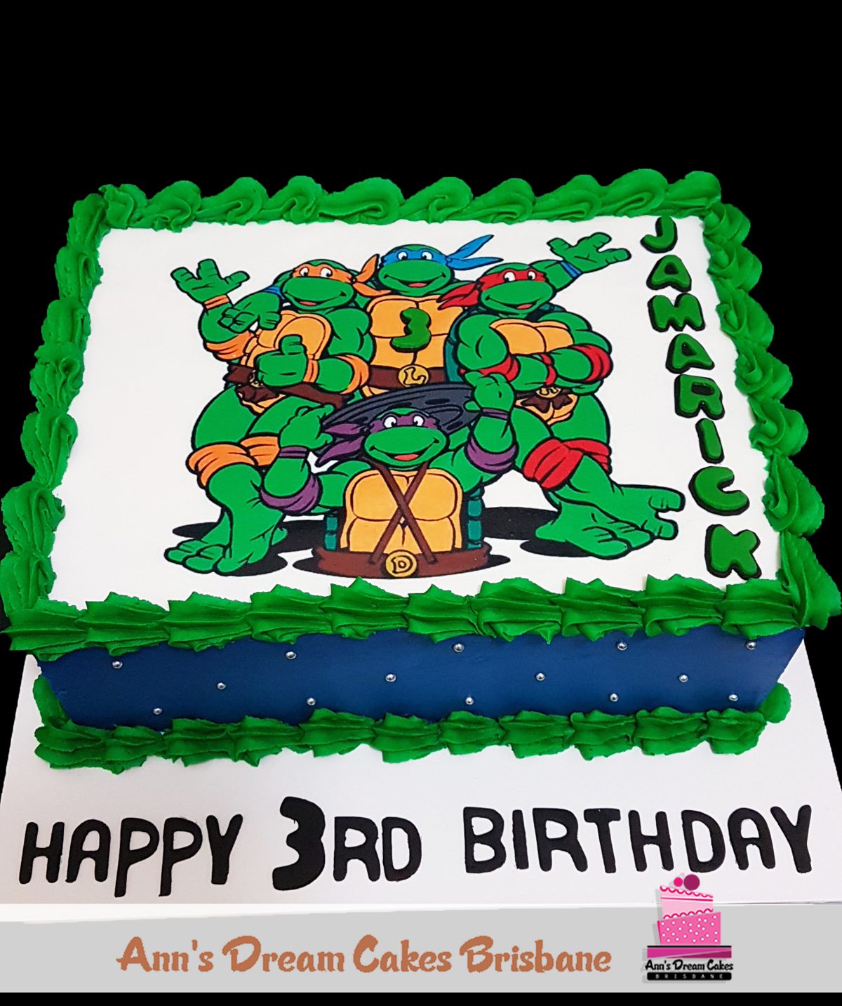 Sheet cake with a printed cartoon turtle design and a child's name for a 3rd birthday