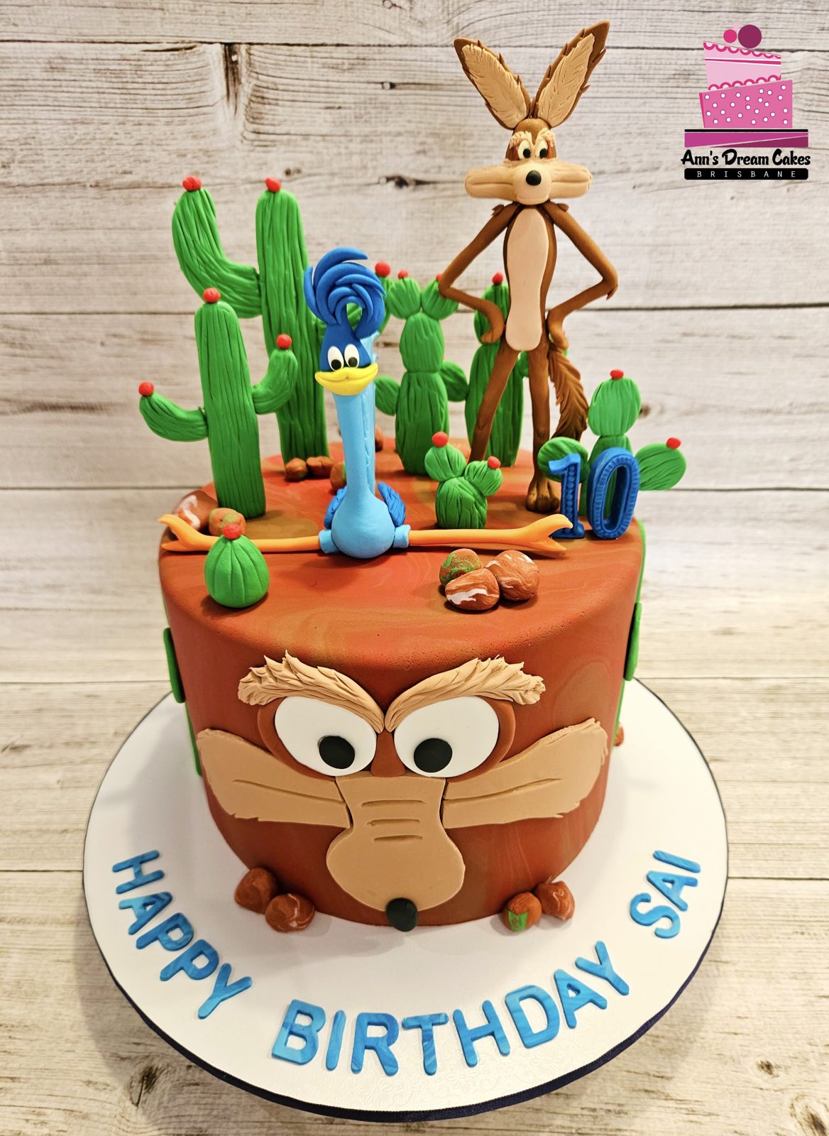 Desert themed 10th birthday cake with cartoon figures and cacti